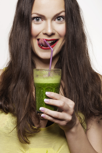 woman drinking green foods drink