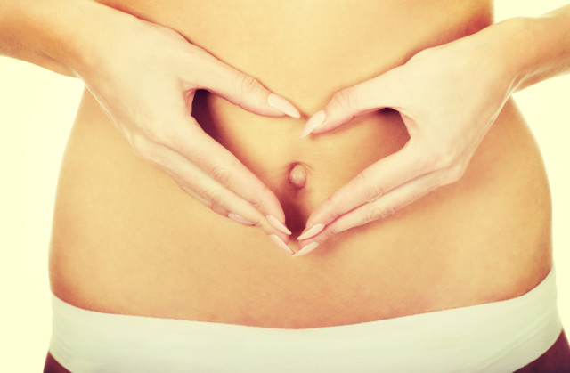 woman with hands over belly, healthy gut