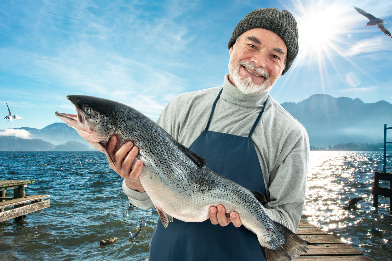 happy fisherman with fresh wild caught salmon